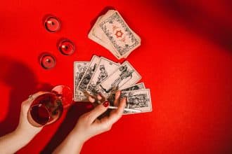 Cartes de tarot tenues par des mains féminines en consultation de voyance